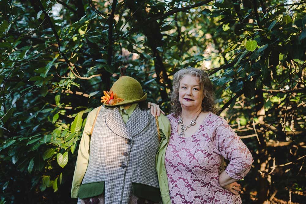 Woman standing next to a dressmakers dummy